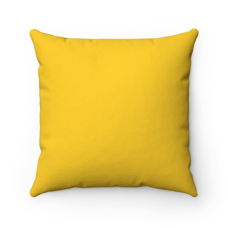 May include: A solid yellow throw pillow with a soft, textured fabric. The pillow is square shaped and has a subtle sheen.