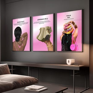 May include: Three framed art prints with pink backgrounds and black frames. Each print features a stylized illustration of a person with dark skin. The prints include text from the Bible: Isaiah 54:17, Jeremiah 29:11, and Psalm 46:5.