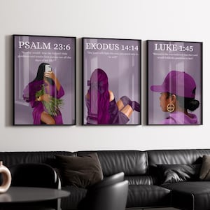 May include: Three framed art prints with illustrations of women in purple attire. The prints feature biblical verses: Psalm 23:6, Exodus 14:14, and Luke 1:45. The artwork is displayed above a black leather sofa.