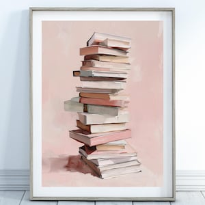 Op de afbeelding: Een ingelijste kunstdruk met een stapel boeken in verschillende kleuren, waaronder roze, wit en beige. De boeken zijn gerangschikt in een hoge, licht gekantelde stapel tegen een zachtroze achtergrond. Het kunstwerk zit in een houten lijst.