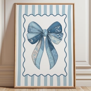 Könnte beinhalten: Ein gerahmter Druck mit einer Aquarellillustration einer blauen Schleife. Die Schleife besteht aus verschiedenen blau gemusterten Stoffen, vor einem weißen Hintergrund mit einem gewellten Rand und hellblauen Streifen. Das Kunstwerk befindet sich in einem Holzrahmen.