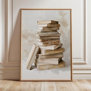 Könnte beinhalten: Ein vertikaler gerahmter Wandkunstdruck, der einen Stapel verwitterter, neutralfarbener Bücher mit abgenutzten Kanten und Goldakzenten an den Buchrücken zeigt. Die Bücher sind in einem hohen, leicht schiefen Stapel in einem hellen Holzrahmen angeordnet.
