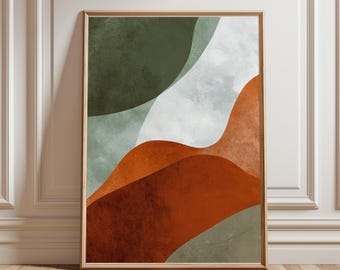May include: Abstract art print in a wooden frame. The artwork features layered shapes in shades of green, white, and rust-orange. The design has a watercolor effect, with soft edges and a textured appearance. The framed art is displayed against a white wall and wooden floor.