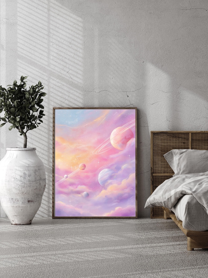 May include: A framed art print featuring a dreamy celestial scene. The artwork depicts planets with rings and clouds in shades of pink, purple, and orange. The print is leaning against a wall, next to a decorative vase and a bed.