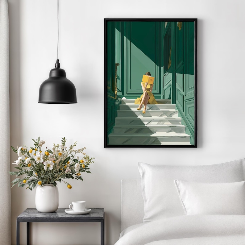 May include: A framed art print depicts a person in a yellow dress reading a book on a staircase. The artwork features a green door and walls, with sunlight casting shadows. A black pendant light hangs above a table with a vase of flowers.