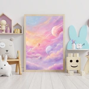 May include: A framed art print featuring a dreamy, pastel-colored space scene. The artwork depicts planets with rings, set against a backdrop of swirling pink, purple, and orange clouds. The print is displayed in a light-colored wooden frame.