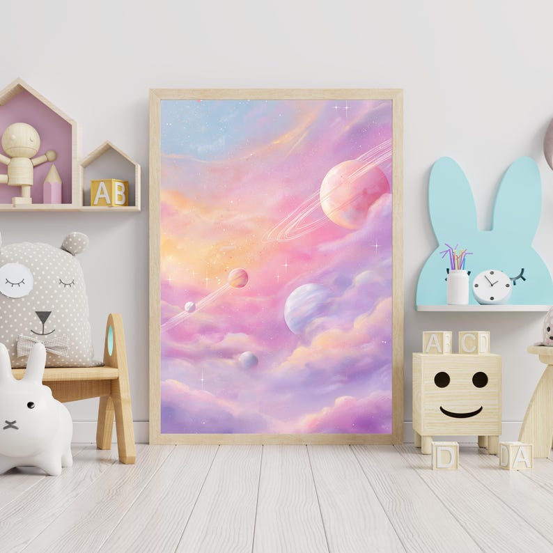 May include: A framed art print featuring a dreamy, pastel-colored space scene. The artwork depicts planets with rings, set against a backdrop of swirling pink, purple, and orange clouds. The print is displayed in a light-colored wooden frame.