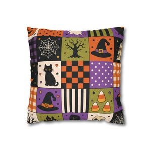 May include: A square throw pillow featuring a patchwork design with Halloween-themed illustrations including a black cat, spider webs, witch hats, candy corn, pumpkins, ghosts, and haunted houses in orange, purple, green, black, and white.