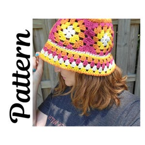 May include: A colorful, crocheted bucket hat in a granny square pattern. The hat features a vibrant mix of pink, yellow, orange, and white squares. The word "Pattern" is written vertically in black script on the left side of the image.