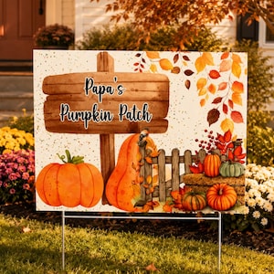 May include: A sign that reads "Papa's Pumpkin Patch" with a watercolor illustration of pumpkins, leaves, and a wooden fence. The sign is displayed on a lawn with autumn foliage and a house in the background.