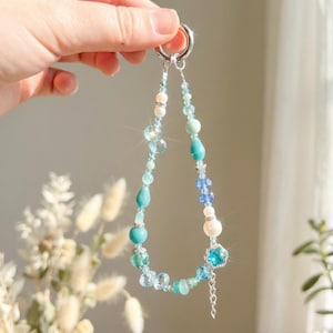 Bracelet pour téléphone turquoise et bleu avec pendentif fleur étoilée, cristaux facettés, bracelet en perles inspiré des vagues de l'océan, gouttelettes transparentes et accent de perles