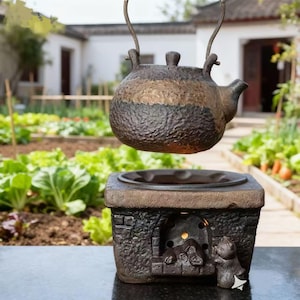 Peut inclure: Une théière rustique marron et bronze suspendue au-dessus d'une base carrée assortie avec une petite figurine d'ours. La théière a une surface texturée et une anse pour la suspendre. La base a une petite ouverture et une empreinte circulaire.