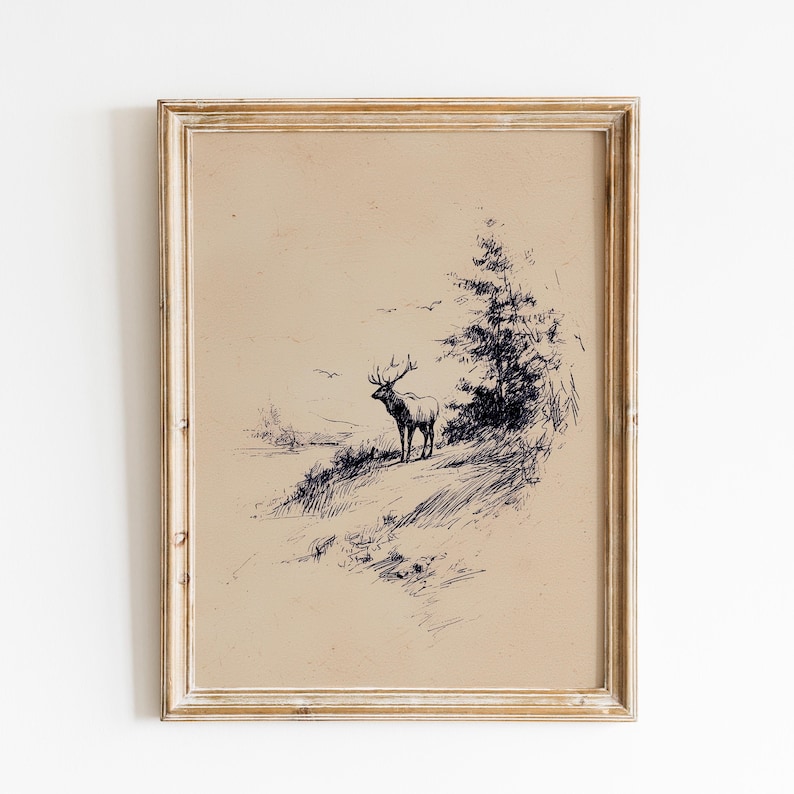 May include: A framed vintage-style print featuring a detailed pen and ink drawing of an elk standing on a hillside. The artwork is in shades of black and white, with a light brown background. The frame is a light wood color.
