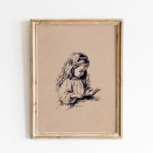May include: A framed sepia-toned print featuring a detailed pen and ink drawing of a young child reading a book. The child has long, flowing hair and is wearing a dress. The artwork is set against a neutral background and framed in a gold-colored frame.