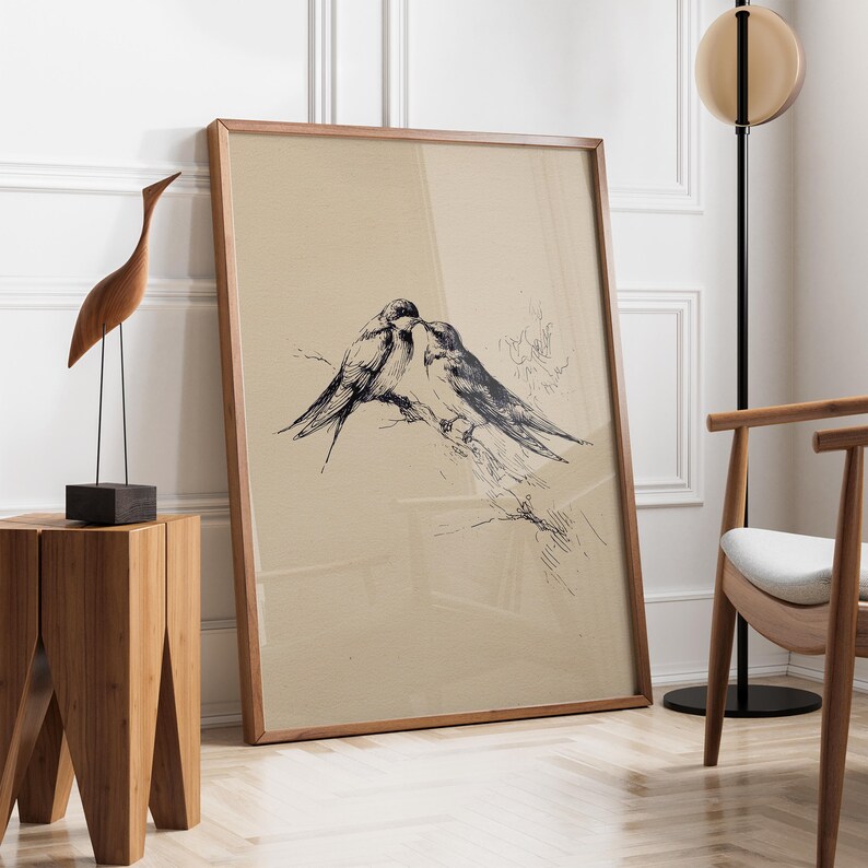 May include: A framed print featuring a black and white illustration of two birds perched on a branch. The artwork has a vintage aesthetic, with a light tan background and a wooden frame. The birds are depicted in a detailed, realistic style.