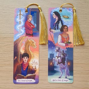 May include: Two fantasy-themed bookmarks with gold tassels. One features a dragon, a wizard, and the text "In a land of myth...". The other shows a woman, a knight on a white horse, and the text "And a time of magic".