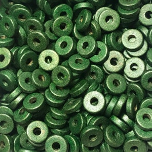 Op de afbeelding: Een grote stapel donkergroene houten kralen met een gat in het midden van elke kraal. De kralen zijn allemaal even groot en even gevormd.