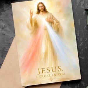 May include: A religious art print depicting Jesus with a bright halo. The image shows Jesus with outstretched hands, with rays of light in red, white, and blue. The text "JESUS, I TRUST IN YOU" is at the bottom of the image.