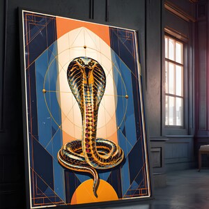 May include: A rectangular framed wall art print featuring a central golden cobra with a flared hood, coiled at the base. The design incorporates geometric lines, a circular sun-like motif, and a colour palette of deep navy blue and vibrant orange.