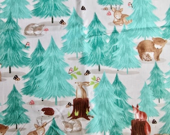 May include: A whimsical fabric design featuring a forest scene with teal-colored pine trees, mushrooms, and various woodland creatures like deer, bears, and rabbits. The pattern is set against a white background, creating a charming and playful aesthetic.