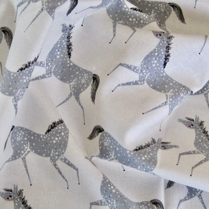 May include: White fabric with a repeating pattern of gray horses with white spots. The horses are stylized and have long legs and necks.