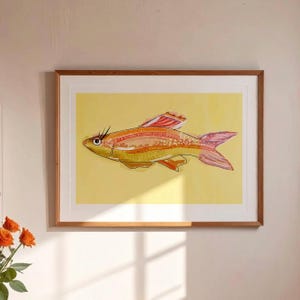 Könnte beinhalten: Ein gerahmter Kunstdruck mit einer stilisierten Fischillustration. Der Fisch hat einen gelben Körper mit orangefarbenen und rosa Details und eine dekorative Flosse. Das Kunstwerk ist vor einem gelben Hintergrund platziert und in einem Holzrahmen gerahmt.
