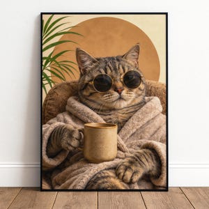 May include: Framed print of a tabby cat wearing sunglasses and a robe, holding a mug. The cat is seated in a chair against a tan circle and green plant backdrop. The artwork has a humorous and relaxed theme.