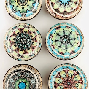 May include: Six round wooden knobs with colorful mandala designs. Each knob features a different intricate pattern with shades of blue, green, yellow, red, and black.