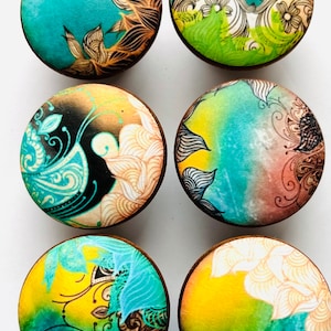 May include: Six round wooden knobs with colorful floral designs. The knobs feature a variety of colors, including blue, green, yellow, and brown. The designs are intricate and detailed, and they would add a touch of whimsy to any piece of furniture.
