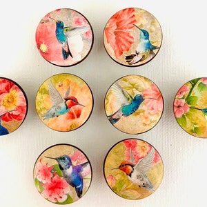 May include: Eight round wooden knobs with colorful floral and hummingbird designs. Each knob features a different hummingbird with vibrant colors and intricate details.