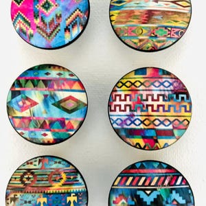 May include: Six round wooden coasters with colorful geometric patterns. The coasters feature a variety of designs, including stripes, diamonds, and zigzags. The coasters are perfect for adding a touch of style to any home.