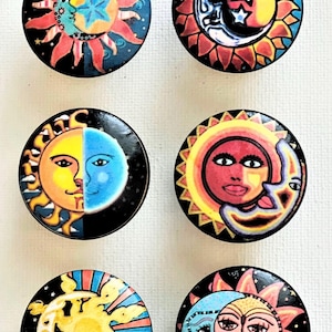 May include: Six round, colorful, ceramic knobs with sun and moon designs. Each knob features a different combination of colors and patterns, including yellow, red, blue, and black.