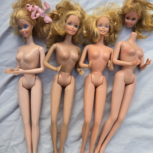 May include: Four vintage fashion dolls with blonde hair and blue eyes. One doll has a pink ribbon in its hair. One doll is missing its head. The dolls are nude and have articulated limbs.