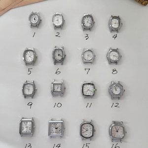 Könnte beinhalten: Auf einer weißen Oberfläche sind sechzehn kleine, silberfarbene Armbanduhren mit verschiedenen Zifferblattformen und -designs angeordnet. Jede Uhr hat einen anderen Stil, darunter ovale, quadratische und rechteckige Zifferblätter. Die Uhren sind von 1 bis 16 nummeriert.