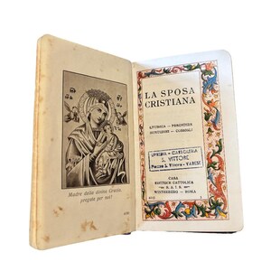 Könnte beinhalten: Ein aufgeschlagenes, altes Buch mit cremefarbenen Seiten. Die linke Seite zeigt eine Schwarz-Weiß-Illustration von Maria und Jesuskind. Die rechte Seite zeigt italienischen Text, darunter "LA SPOSA CRISTIANA" und dekorative Bordüren.