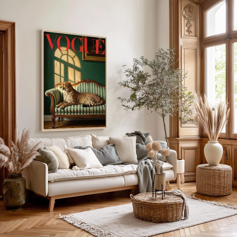 Op de afbeelding: Een ingelijste Vogue-magazinecover met een cheetah op een groen-wit gestreepte bank. Het woord "VOGUE" is rood. De kamer heeft een neutraal kleurenpalet met een witte bank, kussens en houten accenten.