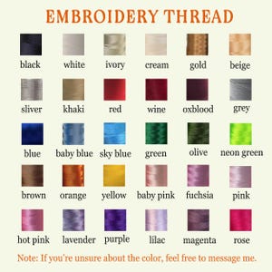 May include: A color chart of embroidery thread in various shades, including black, white, red, blue, and green. The chart displays the color names below each color swatch. The text "EMBROIDERY THREAD" is at the top.