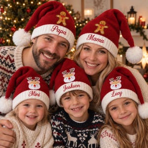 Könnte beinhalten: Ein Set aus fünf rot-weißen Strick-Weihnachtsmützen mit weißen Bommeln. Zwei Mützen zeigen Lebkuchenmann-Stickereien und die Namen Papa und Mama. Drei Mützen zeigen Rentier-Stickereien und die Namen Mini, Jaskson und Lucy.