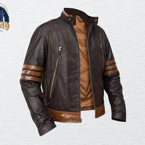 May include: A brown leather jacket with a stand-up collar and a brown interior. The jacket features brown stripes on the sleeves and two zipped pockets. The logo "Quality One Jackets" is in the upper left corner.