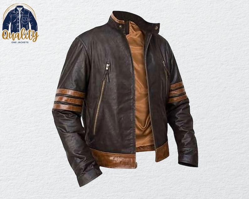 May include: A brown leather jacket with a stand-up collar and a brown interior. The jacket has brown stripes on the sleeves and two zippered pockets. The logo "Quality One Jackets" is in the upper left corner.