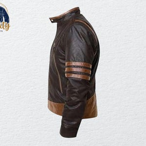 May include: A brown leather jacket with a stand-up collar and a zipper closure. The jacket features brown stripes on the sleeves and a brown trim at the bottom. The logo "Quality One Jackets" is in the upper left corner.