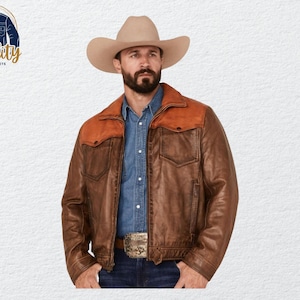 Op de afbeelding: Een bruine leren jas met een contrasterende oranje juk en kraag, gedragen over een spijkerblouse. De jas heeft twee borstzakken en een gesp. De persoon draagt een beige cowboyhoed. Het logo "Quality One Jackets" staat linksboven.