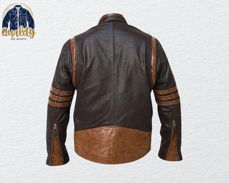 May include: A brown and tan leather jacket with a classic design. The jacket features brown stripes on the sleeves and a brown lower panel. The jacket has a zipper closure on the sleeves and a collar. The logo "Quality One Jackets" is in the upper left corner.