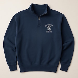 Puede incluir: Sudadera azul marino con cremallera de cuarto de cuello alto y cremallera plateada. La sudadera presenta el texto "SCOUT AND SONNY MOCKUPS" en una fuente blanca estilizada en el pecho izquierdo.