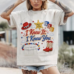 May include: A cream-colored t-shirt featuring a graphic print with a red cowboy hat, a yellow sheriff star badge labeled Infinity and Beyond, red and blue blocks labeled TS 5, red cowboy boots, and a beaded bracelet with the text You've Got A Friendime.