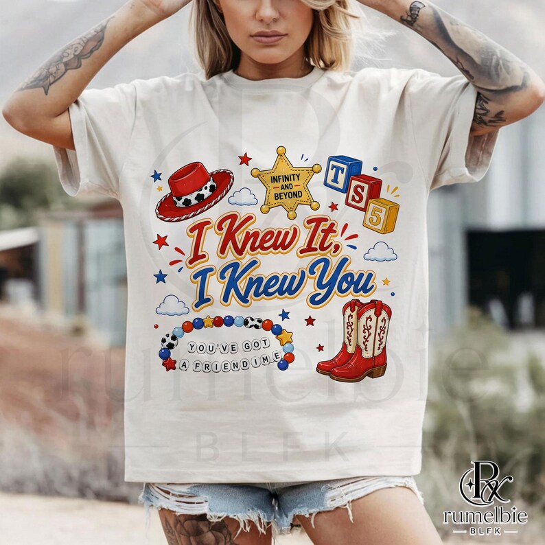 May include: A cream-colored t-shirt featuring a graphic print with a red cowboy hat, a yellow sheriff star badge labeled Infinity and Beyond, red and blue blocks labeled TS 5, red cowboy boots, and a beaded bracelet with the text You've Got A Friendime.