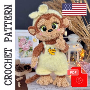 Puede incluir: Una muñeca de mono de ganchillo con un peto amarillo con un parche de plátano. El mono tiene pelaje marrón, un sombrero color crema y ojos grandes y expresivos. La imagen incluye el texto "CROCHET PATTERN" y un icono de descarga PDF.