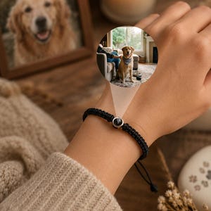 Könnte beinhalten: Schwarz geflochtenes Armband mit dunklem Steinakzent. Das Armband befindet sich an einem Handgelenk, mit einem gerahmten Foto eines Golden Retrievers und einem kreisförmigen Bild eines Hundes mit Bandana. Eine brennende Kerze und Trockenblumen sind ebenfalls im Bild.