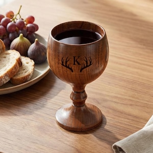 May include: A white ceramic mug with a black handle and the text "But First, Coffee" in a handwritten style. The mug is on a white surface. The mug is approximately 4 inches tall.