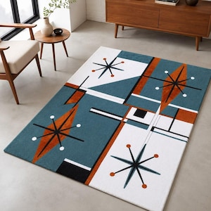 Könnte beinhalten: Ein rechteckiger Teppich mit einem geometrischen Muster in den Farben Petrol, Weiß und gebranntem Orange. Das Design umfasst schwarze Sternmotive, scharfe, kantige Formen und gerade Linien, die eine strukturierte Komposition bilden.